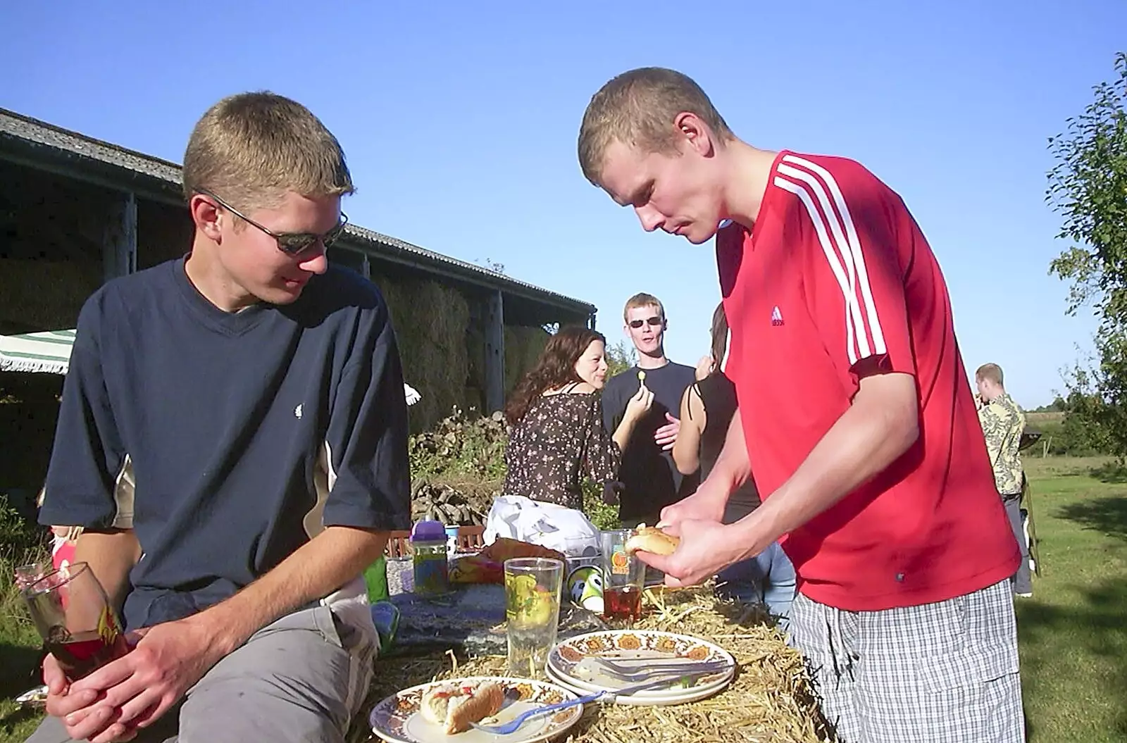 The Boy Phil looks warily at Bill's sausage, from A Rabbit Barbeque, Dairy Farm, Thrandeston - 14th September 2003