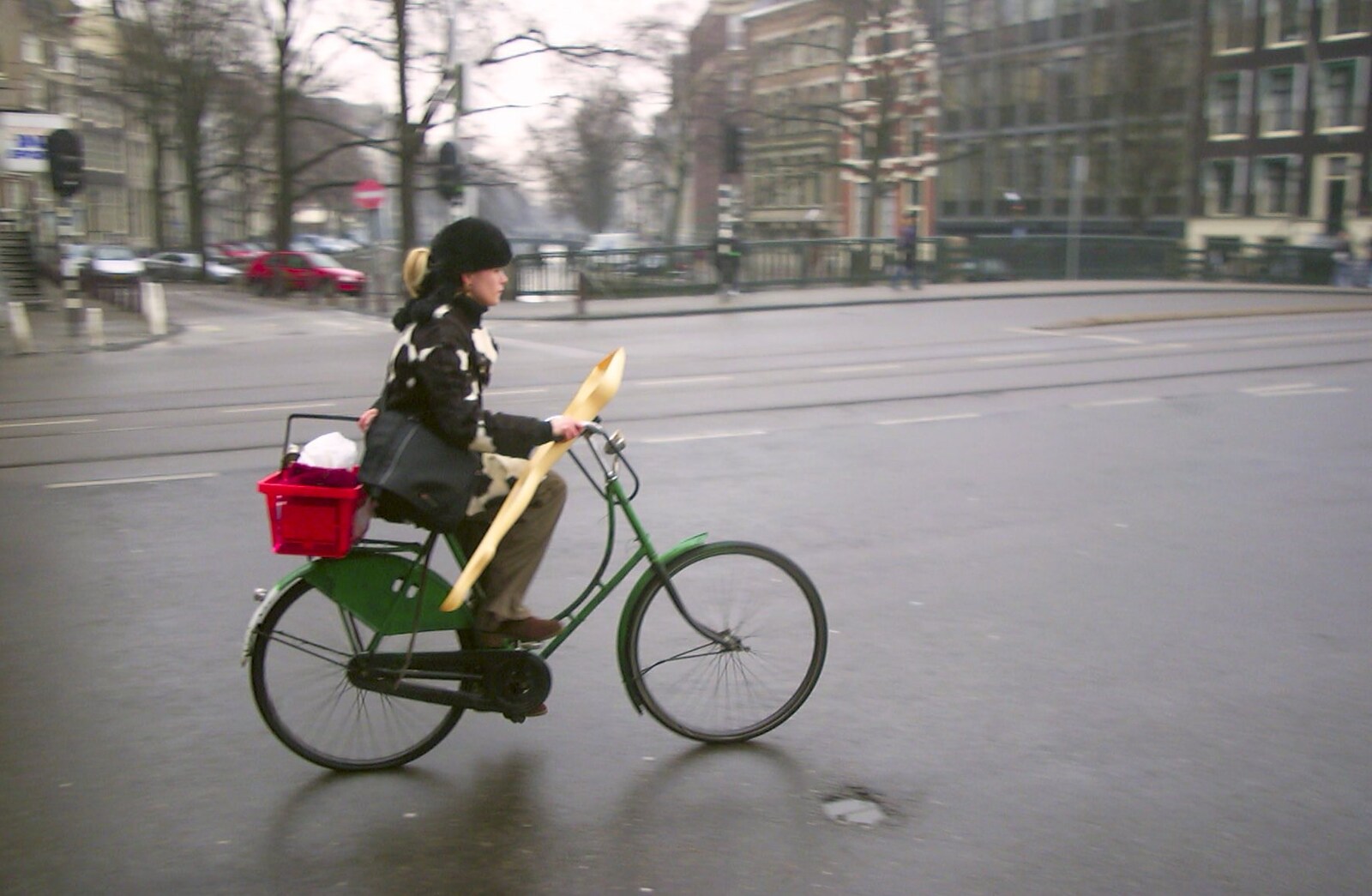 A woman cycles past whilst holding a plastic leg from Anne Frank, Markets and Mikey-P's Stag Do, Amsterdam, Netherlands - 6th March 2004