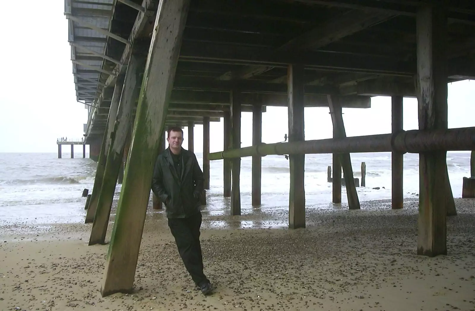 Nosher leans against the pier supports, from Moping in Southwold, Suffolk - 3rd April 2004