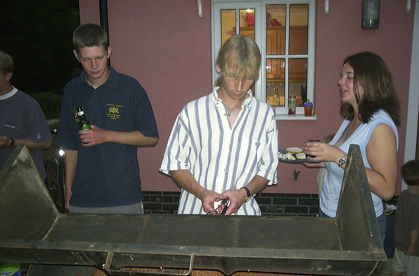 Jimmy pokes the barbeque from The BSCC in Debenham, and Bill's Housewarming Barbie, Yaxley, Suffolk - 31st July 2004