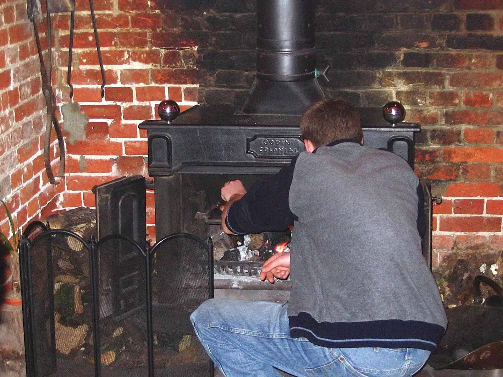 The Boy Phil pokes the fire, from Sausages at the Swan Inn, and Revs Gets Decorated, Diss and Brome - 7th January 2005