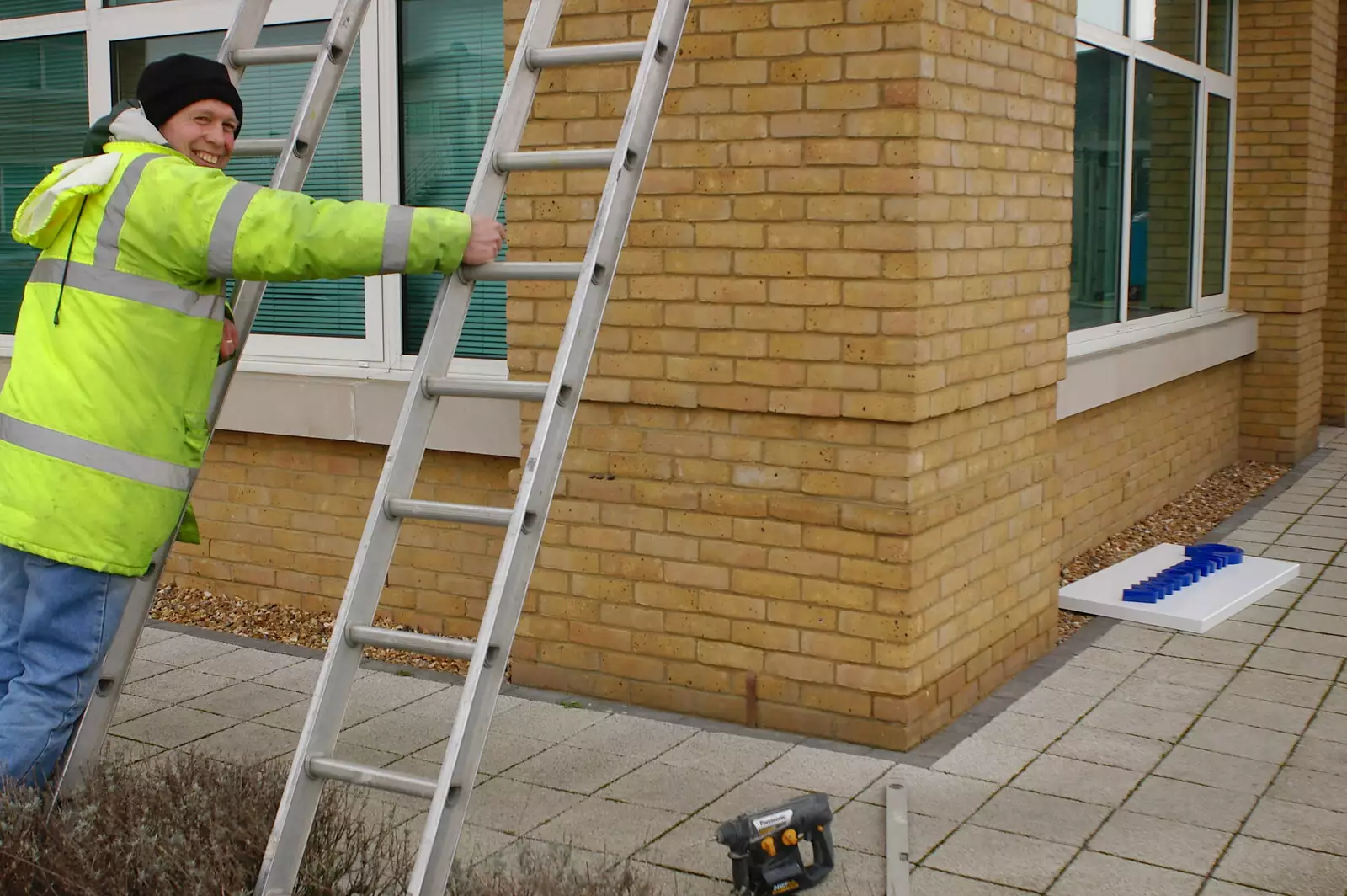 The sign dude holds on to a ladder, from Wendy Leaves "The Lab" and a Snow Day, Cambridge and Brome - 25th February 2005