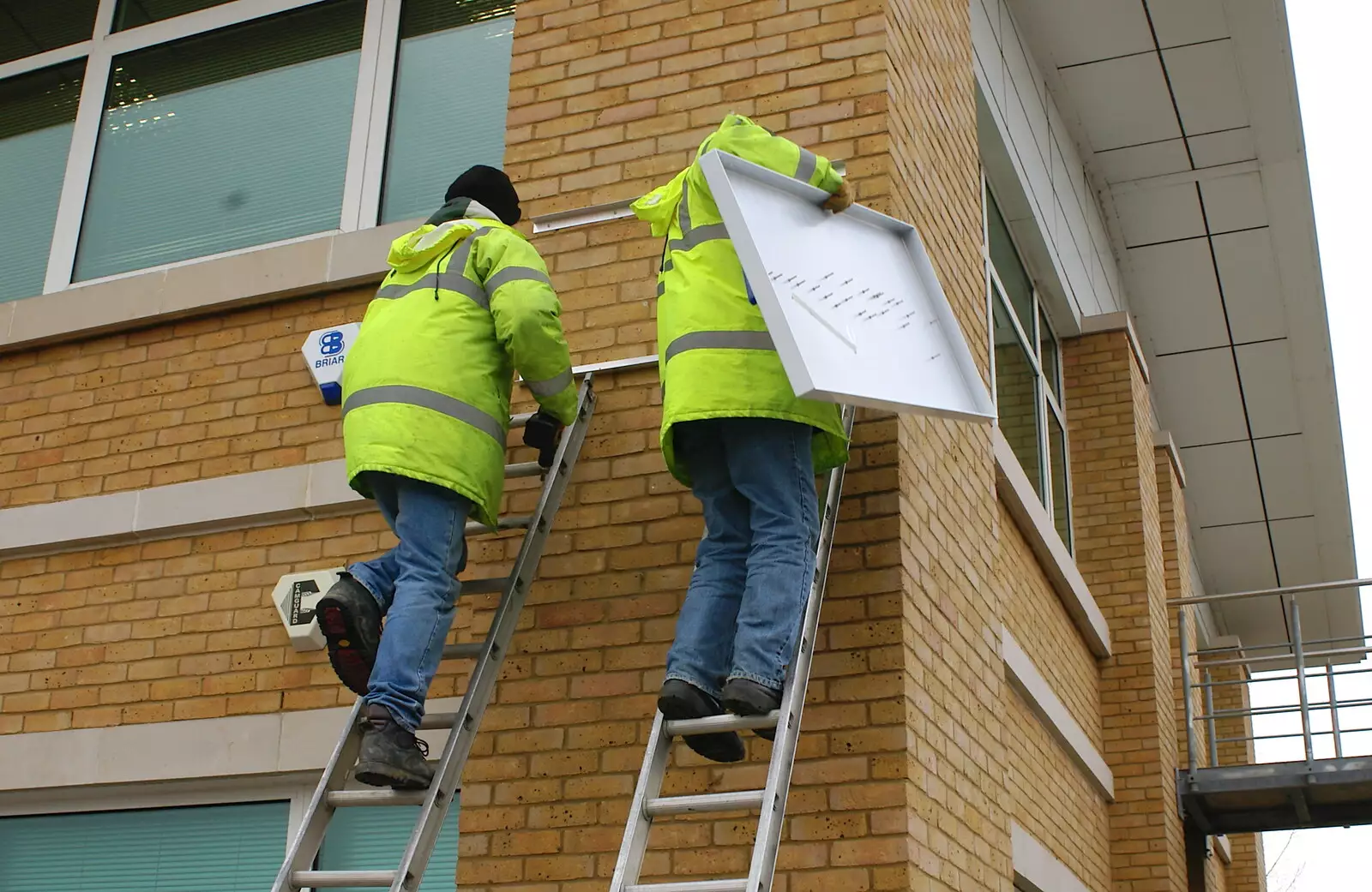 The new sign is hauled up, from Wendy Leaves "The Lab" and a Snow Day, Cambridge and Brome - 25th February 2005