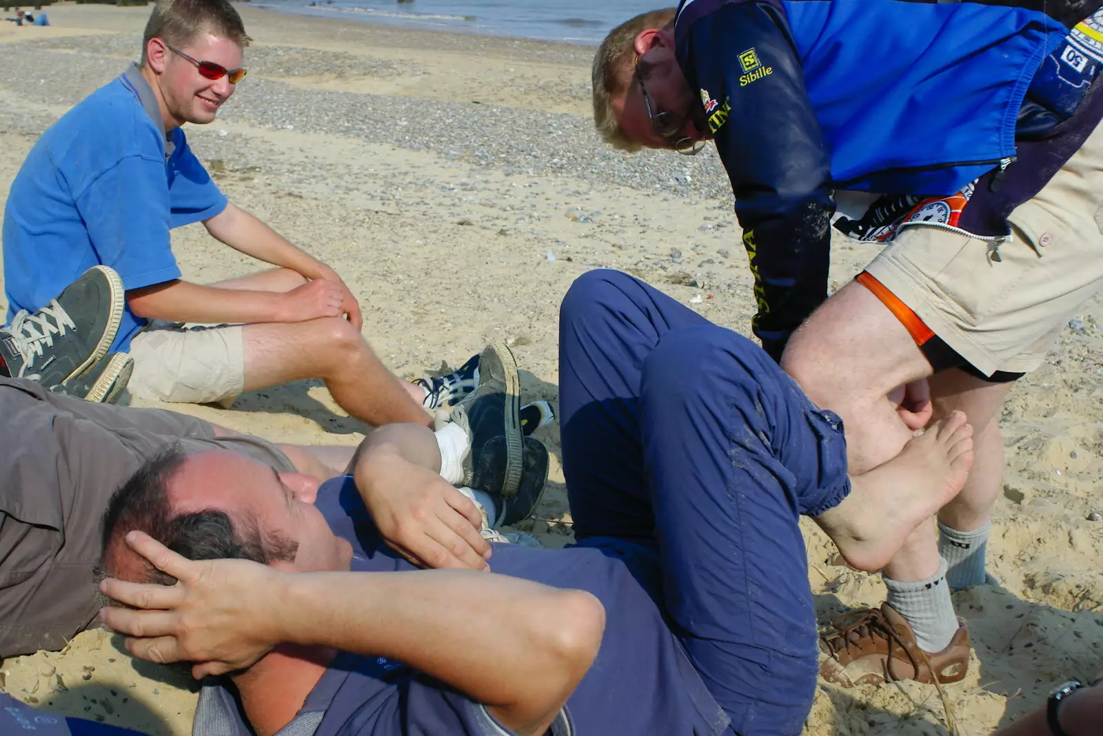 Marc does something to DH's feet, from The BSCC Charity Bike Ride, Walberswick, Suffolk - 9th July 2005