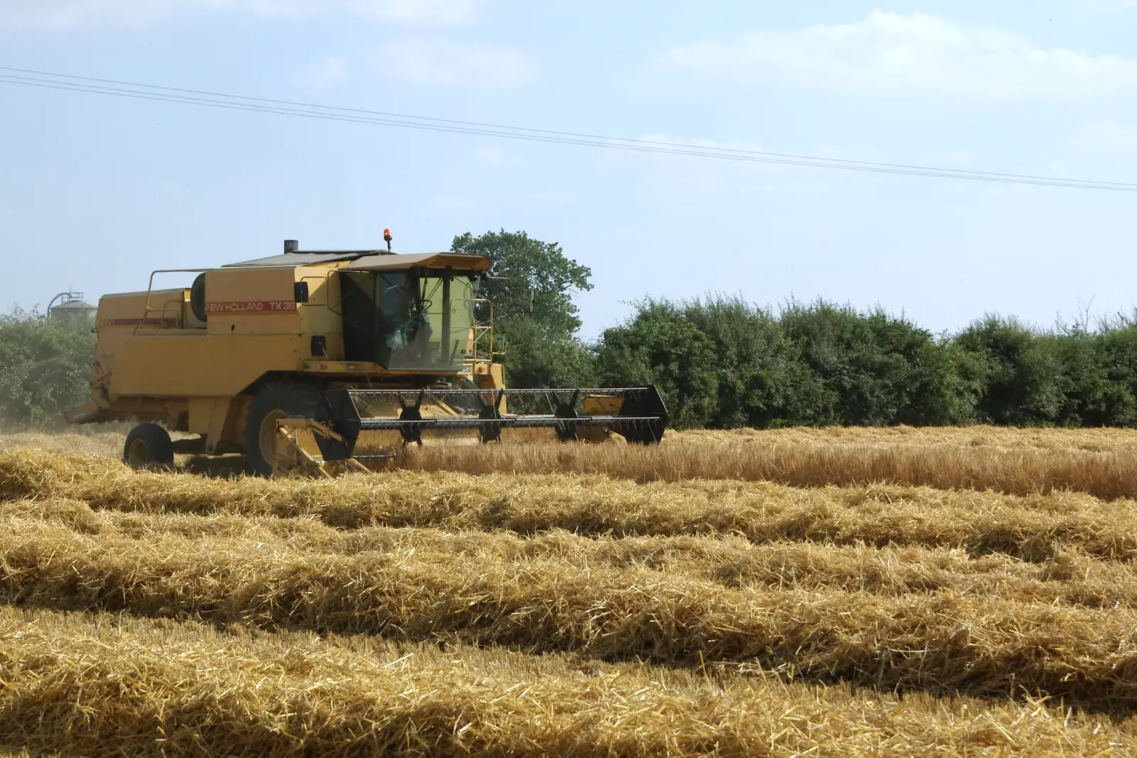 A New Holland trundles around, from Steve Ives' Leaving Lunch, Science Park, Cambridge - 11th July 2005