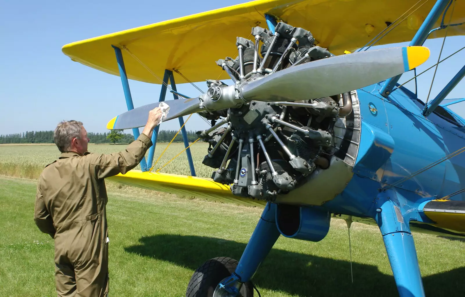 Splattered bugs are cleaned off the Stearman's propeller, from A Day With Janie the P-51D Mustang, Hardwick Airfield, Norfolk - 17th July 2005