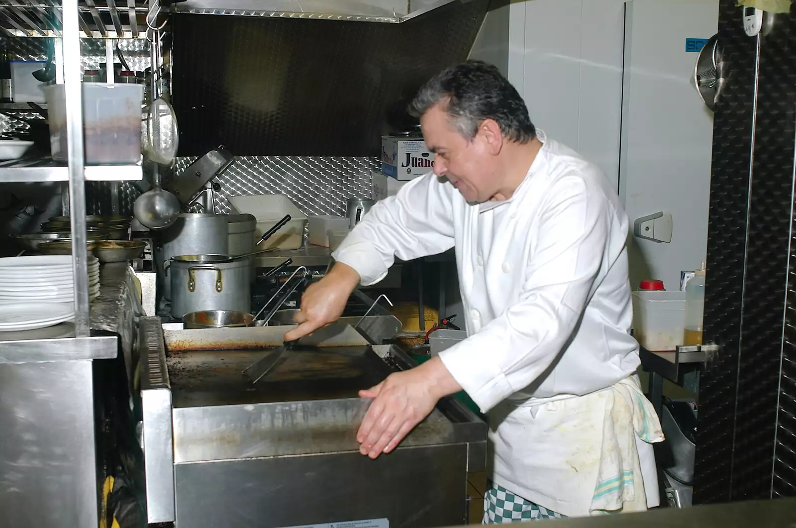 A hotplate is scraped down, from Borough Market and North Clapham Tapas, London - 23rd July 2005