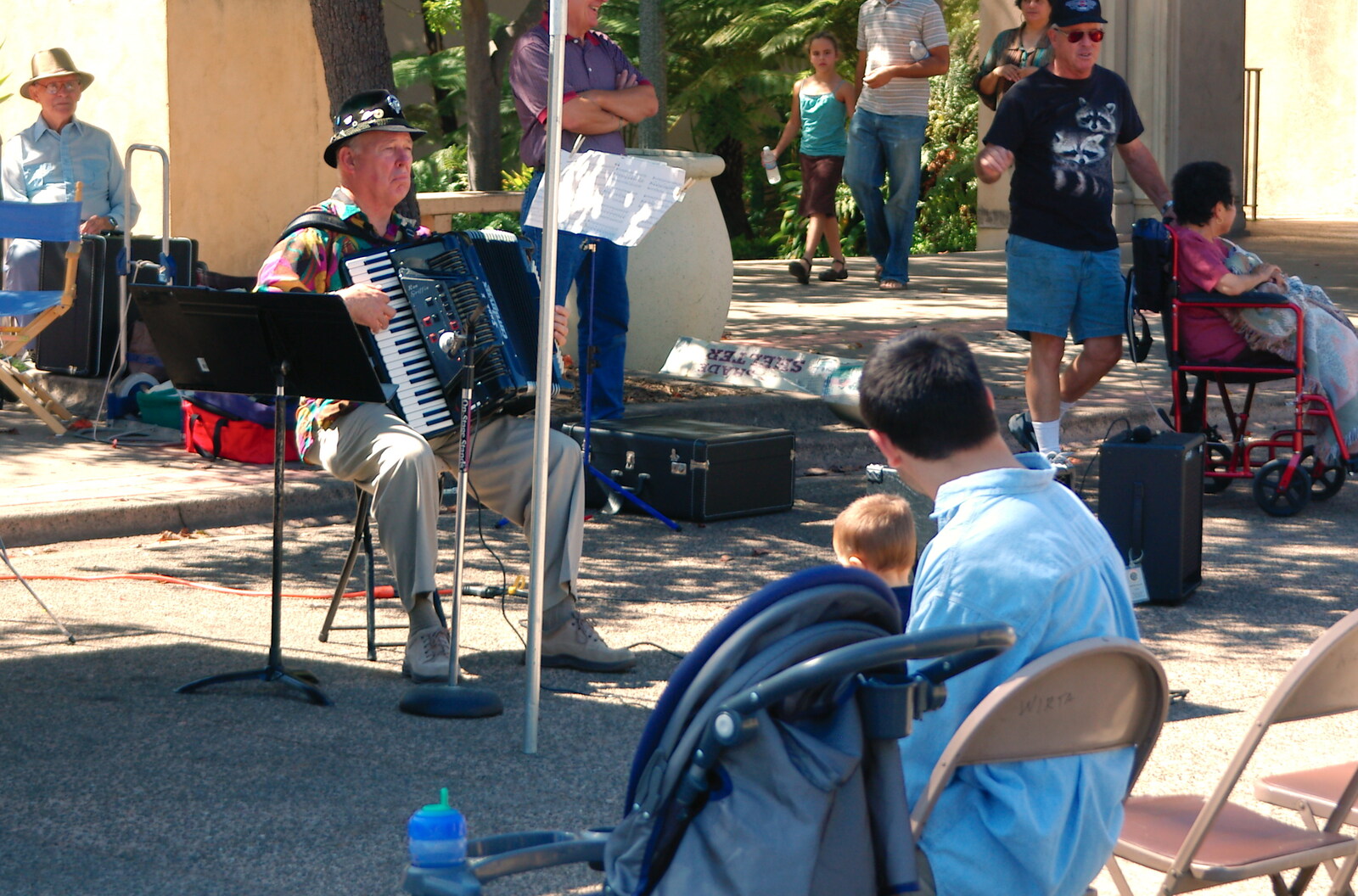 Scenes and People of Balboa Park, San Diego, California - 25th September 2005: A couple of people watch an accordion player