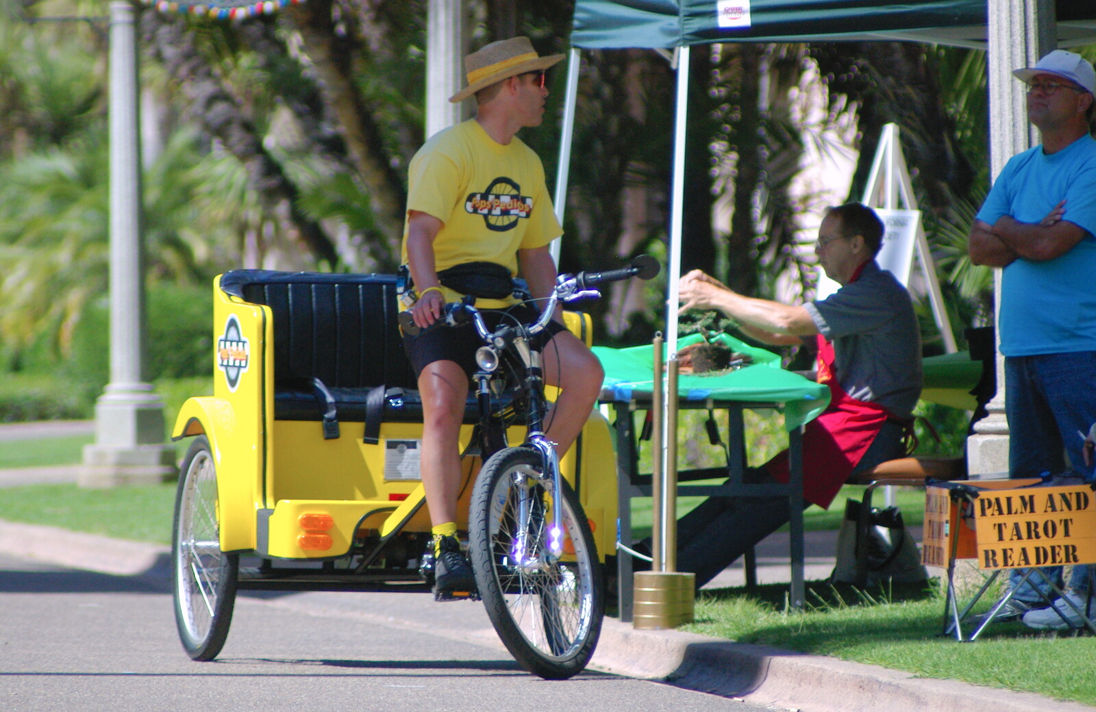 Scenes and People of Balboa Park, San Diego, California - 25th September 2005: A dude on a cycle rickshaw gets a Tarot reading