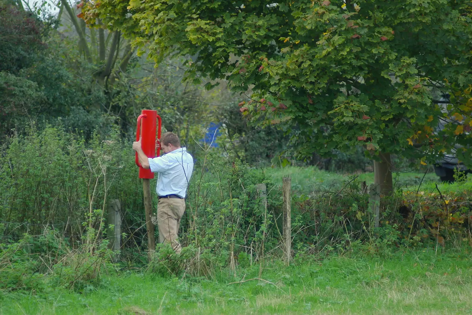 Someone pounds fence posts in around a field, from Suffolk County Council Dereliction, and Cotton Flamenco, Suffolk - 22nd October 2005