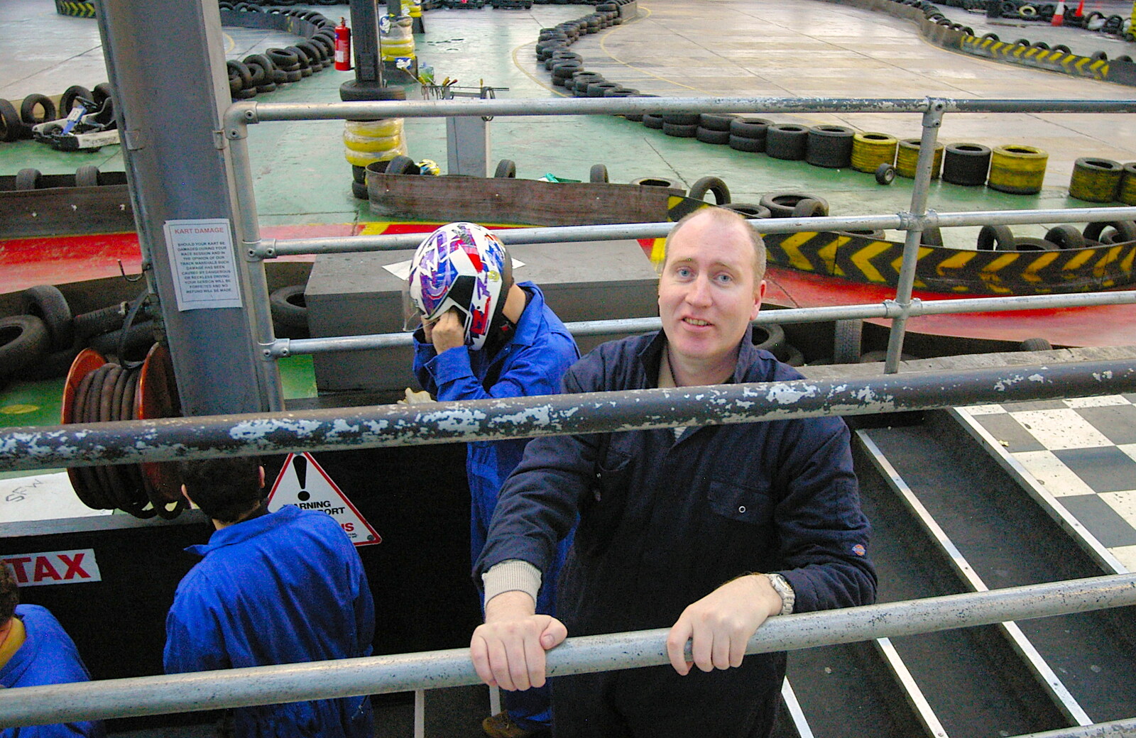Russell McHugh hangs off a railing from Qualcomm goes Karting in Caxton, Cambridgeshire - 7th November 2005