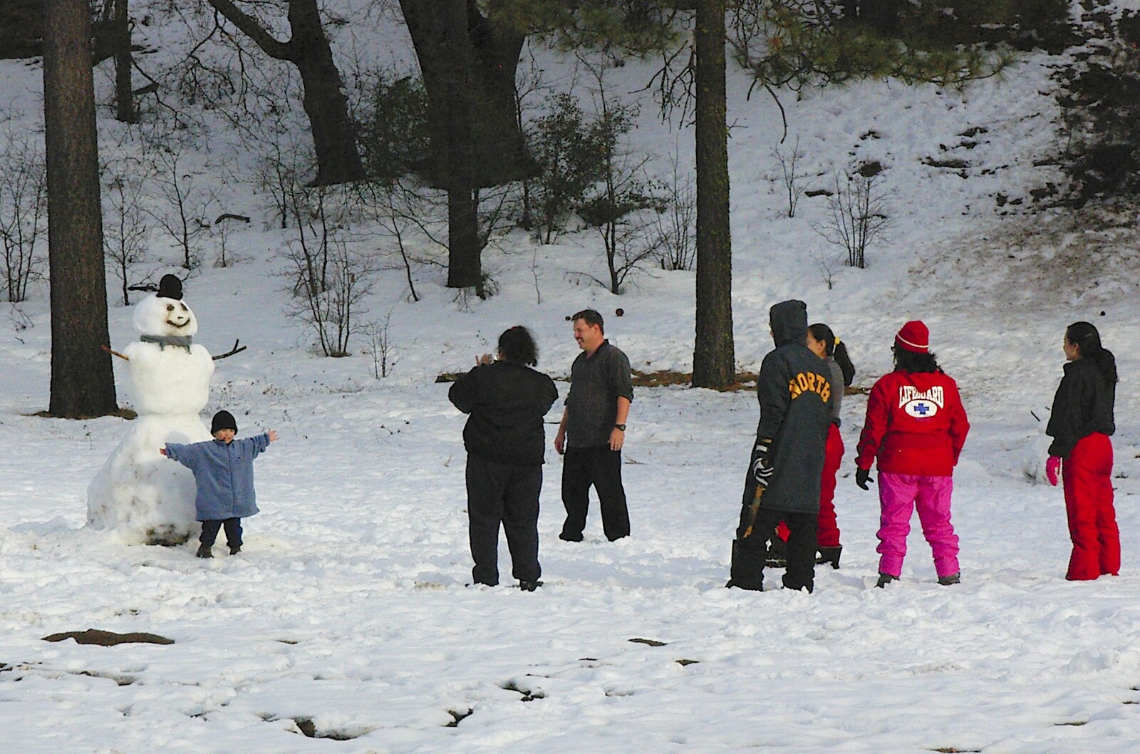 A kid emulates his snowman from California Snow: San Bernadino State Forest, California, US - 26th March 2006