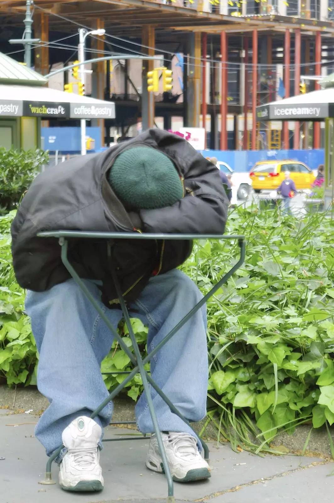 A homeless guy sleeps on a café table, from A Union Square Demo, Bryant Park and Columbus Circle, New York, US - 2nd May 2006