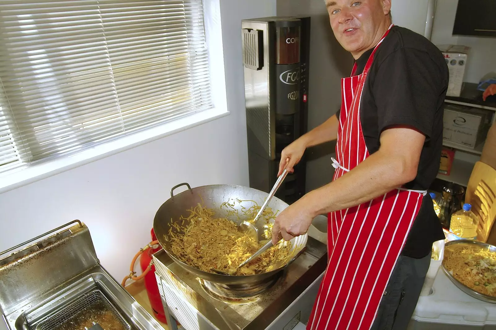 The food guy stirs stuff in a massive wok, from Qualcomm's New Office Party, Science Park, Milton Road, Cambridge - 3rd July 2006