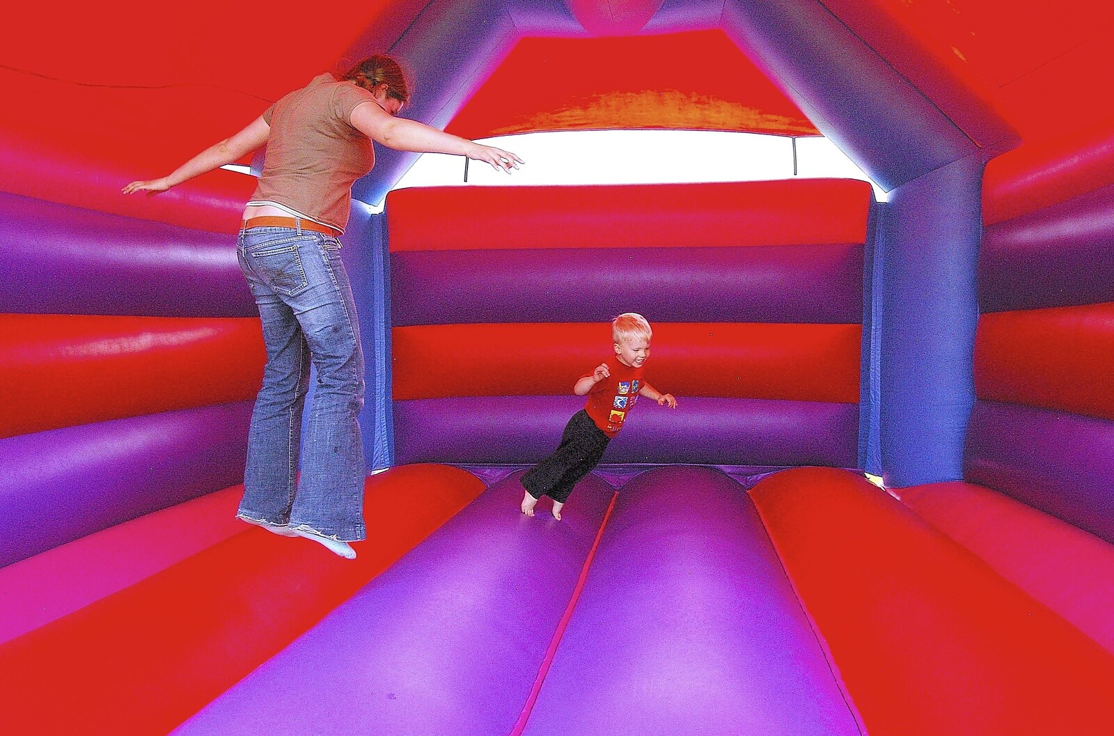 Isobel and Ryan leap about in the bouncy castle from Qualcomm's Summer Circus Thrash, Churchill College, Cambridge - 18th August 2006