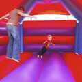 Isobel and Ryan leap about in the bouncy castle, Qualcomm's Summer Circus Thrash, Churchill College, Cambridge - 18th August 2006