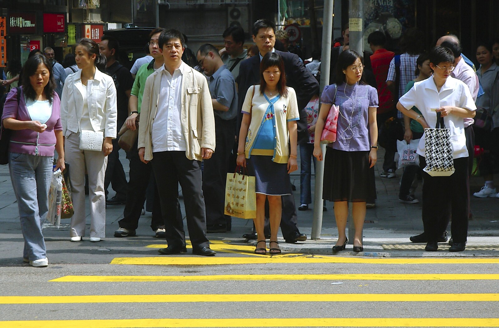 People wait to cross over the busy street from Wan Chai and Central, Hong Kong, China - 2nd October 2006