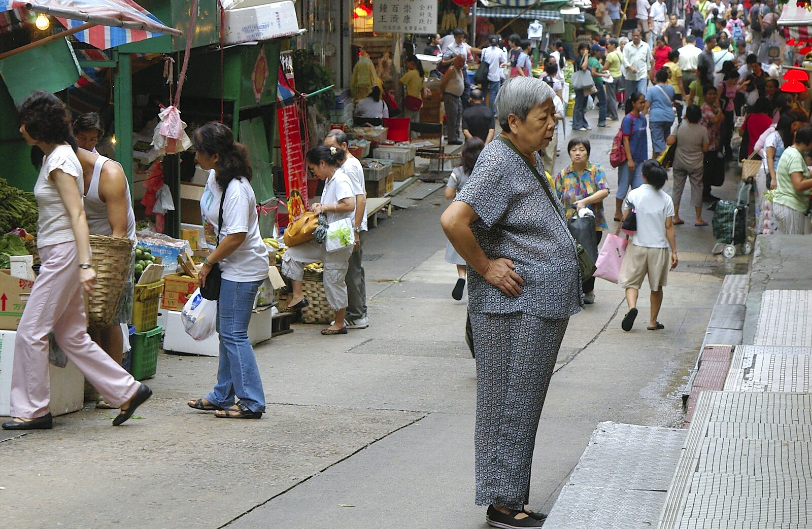 A portly woman looks in to a shop doorway from Lan Kwai Fong Market, Hong Kong, China - 4th October 2006