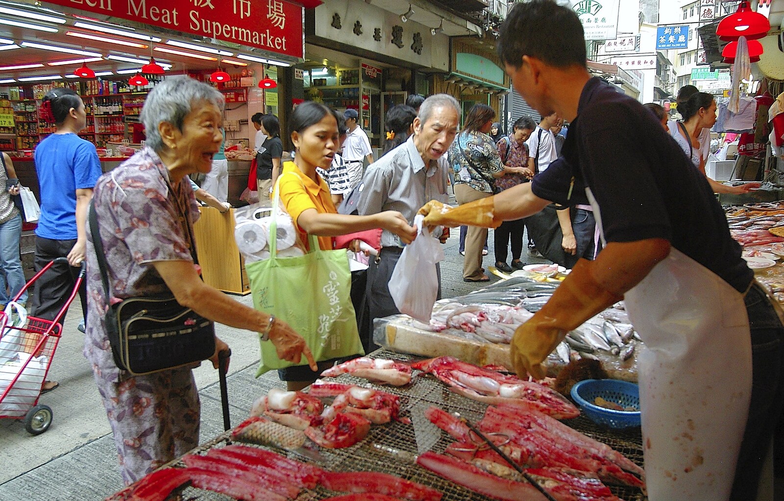 An old woman points at fish and shouts from Lan Kwai Fong Market, Hong Kong, China - 4th October 2006