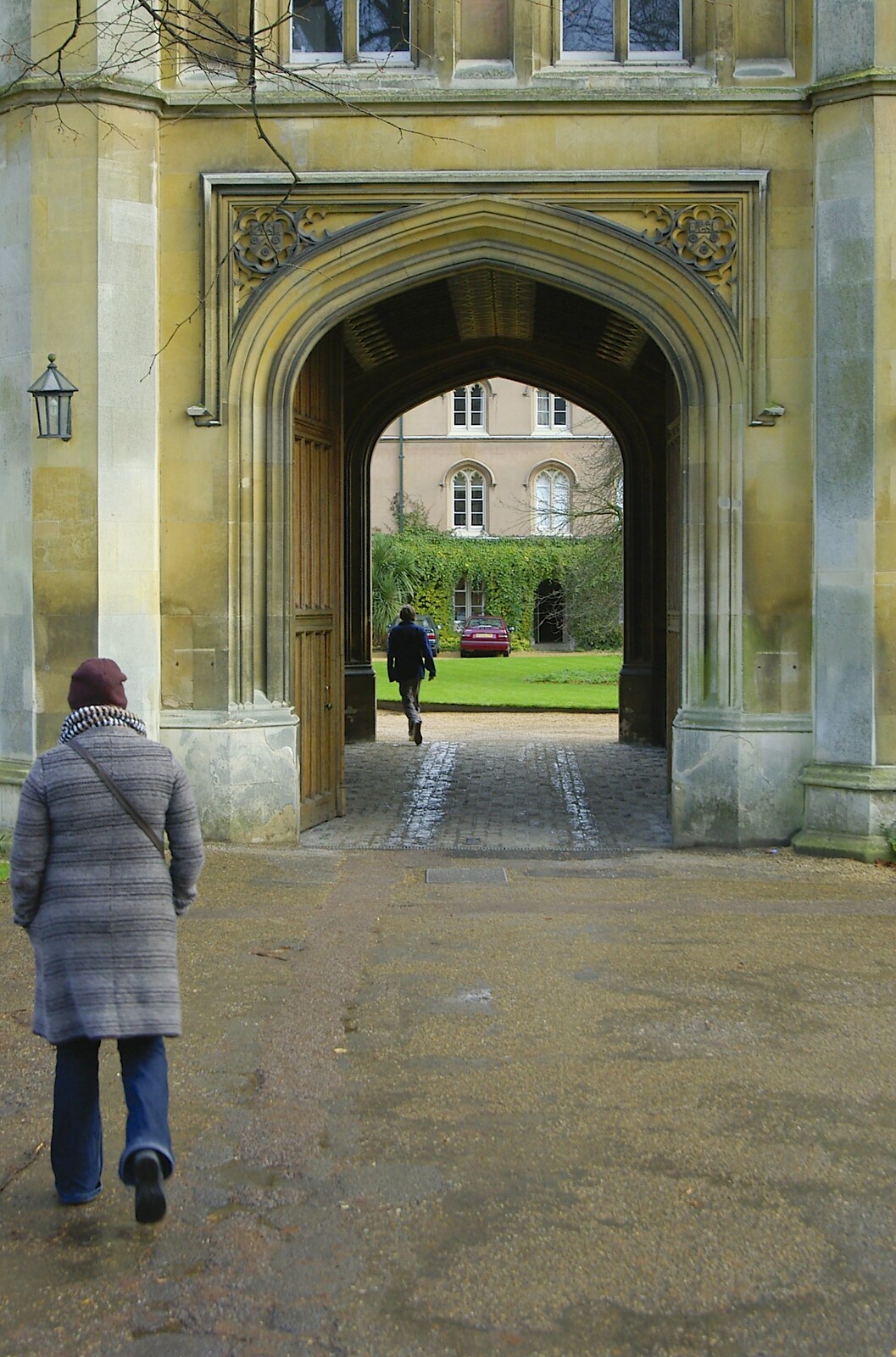 Isobel walks up to a college entrance from Autumn Colleges: a Wander around The Backs, Cambridge - 26th November