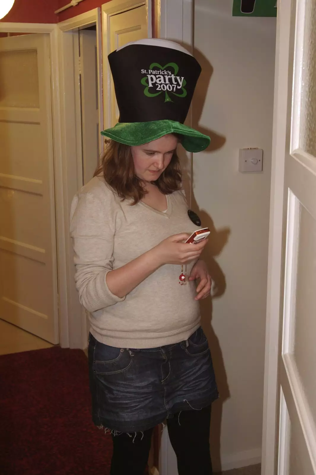 Isobel with novelty hat sends a text, from Finningham Gospel Hall and Isobel's House Warming, Ward Road, Cambridge - 17th March 2007