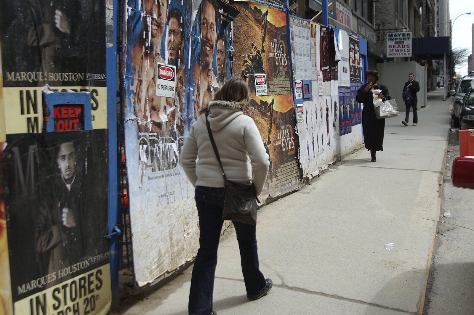 Crossing Brooklyn Bridge, New York, US - 26th March 2007: Isobel walks past some pasted posters