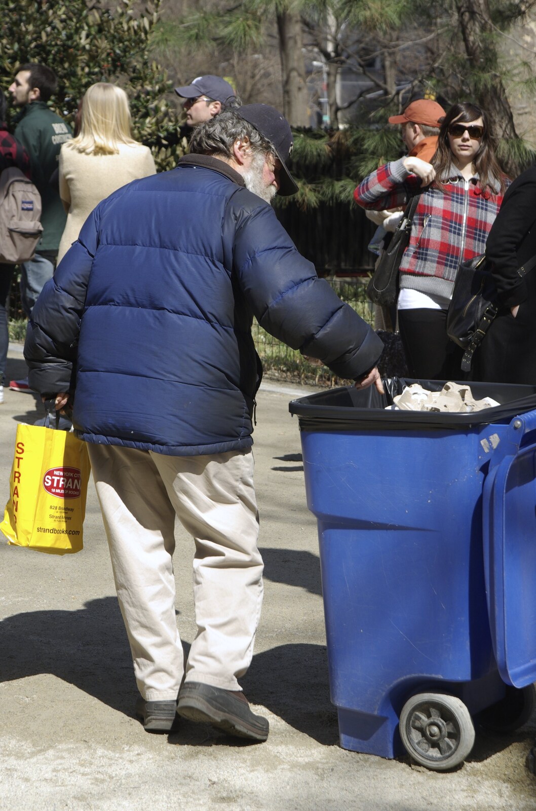 Crossing Brooklyn Bridge, New York, US - 26th March 2007: A homeless dude checks the bins for food