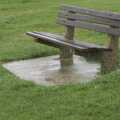 A rain-soaked bench sits empty on the clifftop