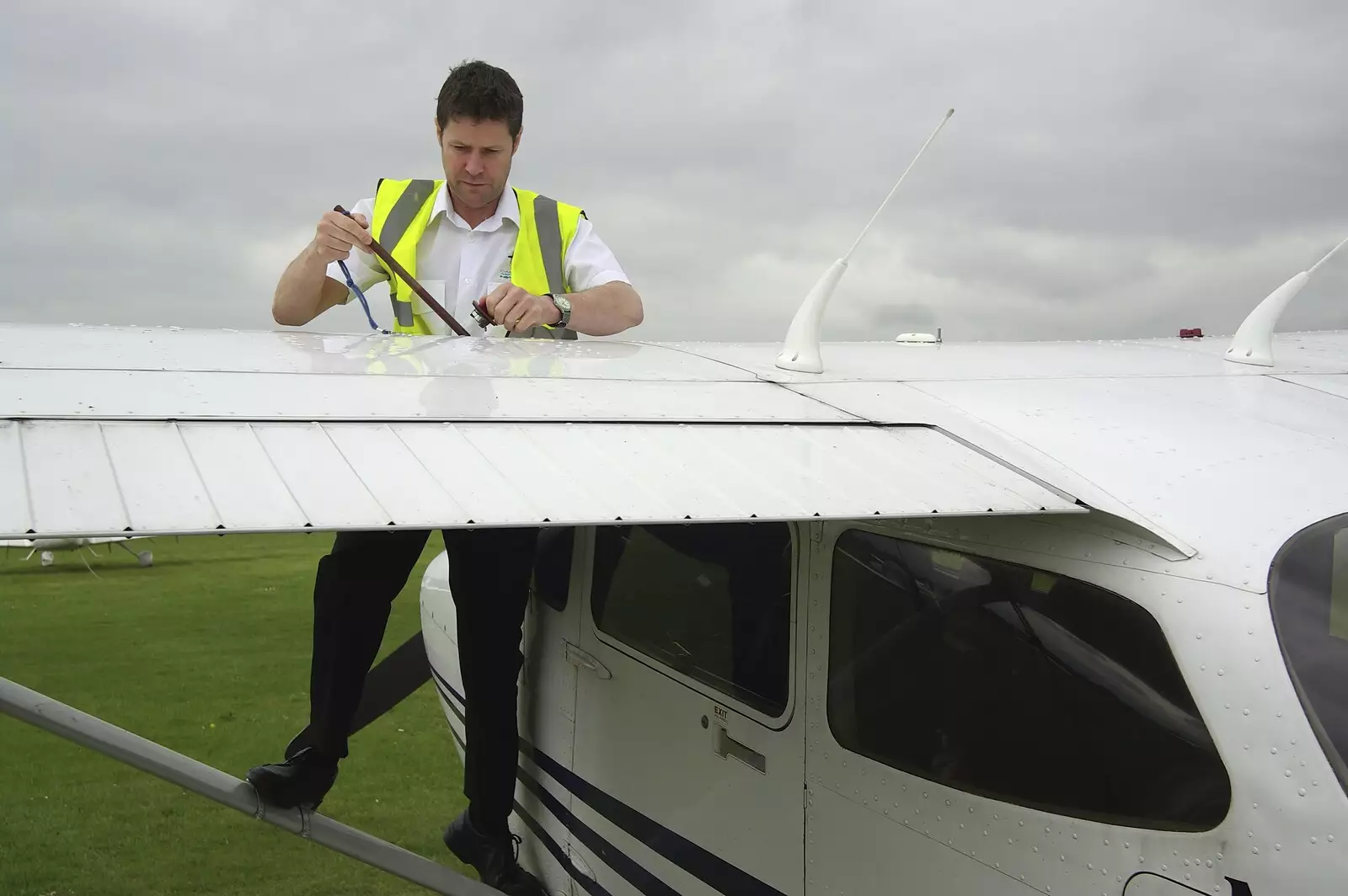 The instructor checks the fuel levels, from Nosher Flies a Plane, Cambridge Airport, Cambridge - 28th May 2008