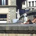 A dude chills out with a ciggy on the pontoon of a bridge