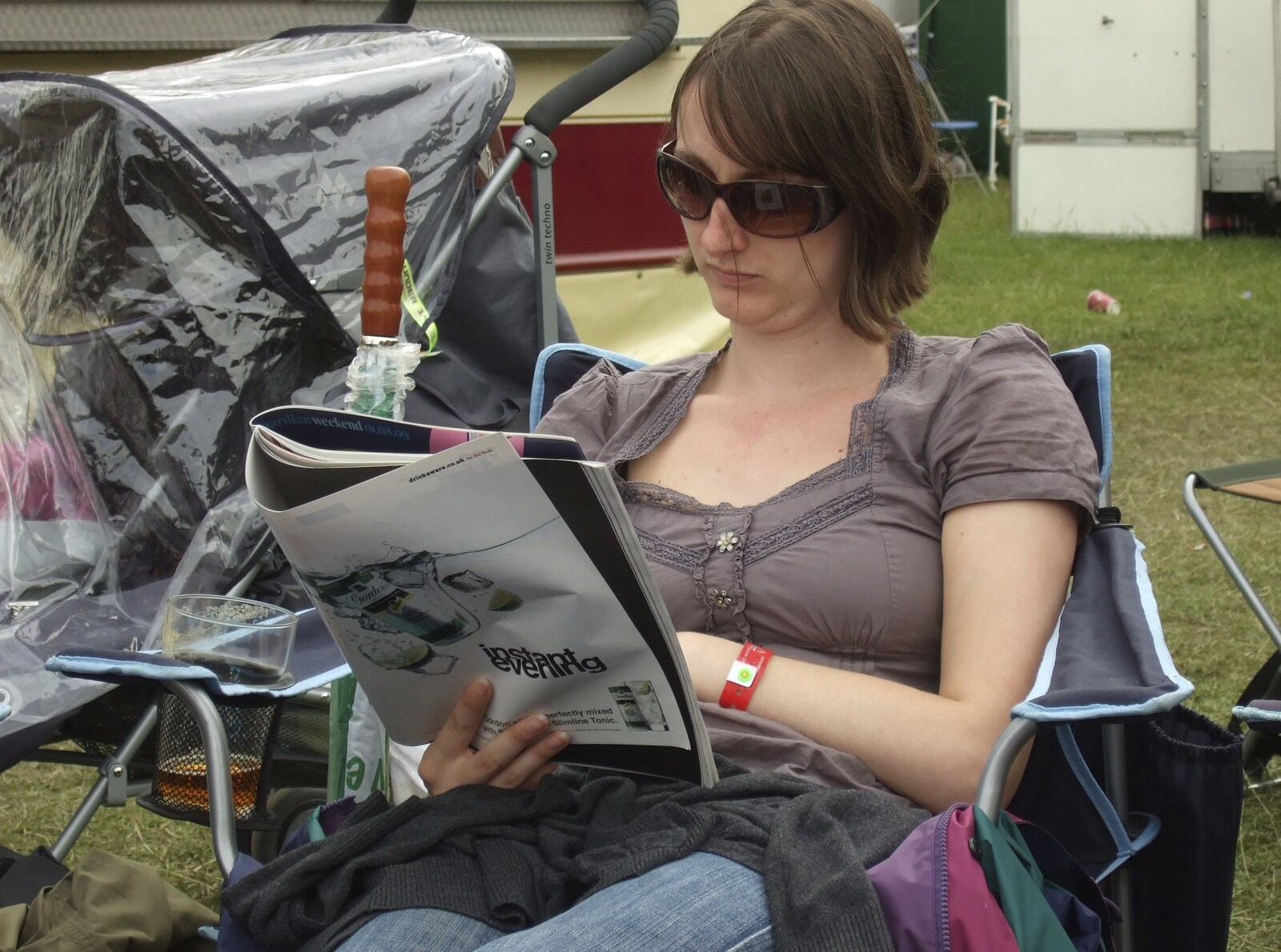 Emma reads a magazine from The Cambridge Folk Festival, Cherry Hinton Hall, Cambridge - 1st August 2009