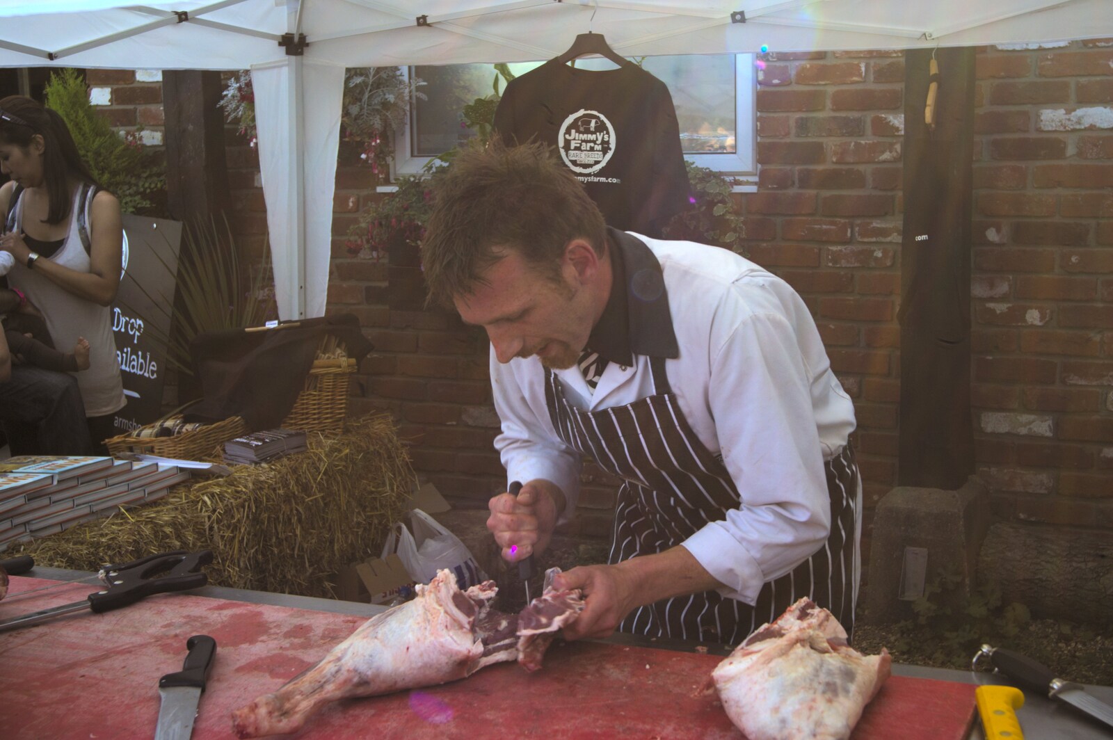 A butcher hacks away at a lamb leg from Harvest Festival at Jimmy's Farm, Wherstead, Suffolk - 12th September 2009