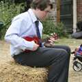 Eoghan plays ukulele on a straw bale, Nosher and Isobel's Wedding, Brome, Suffolk - 3rd July 2010