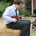 Eoghan plays ukulele on a straw bale, Nosher and Isobel's Wedding, Brome, Suffolk - 3rd July 2010
