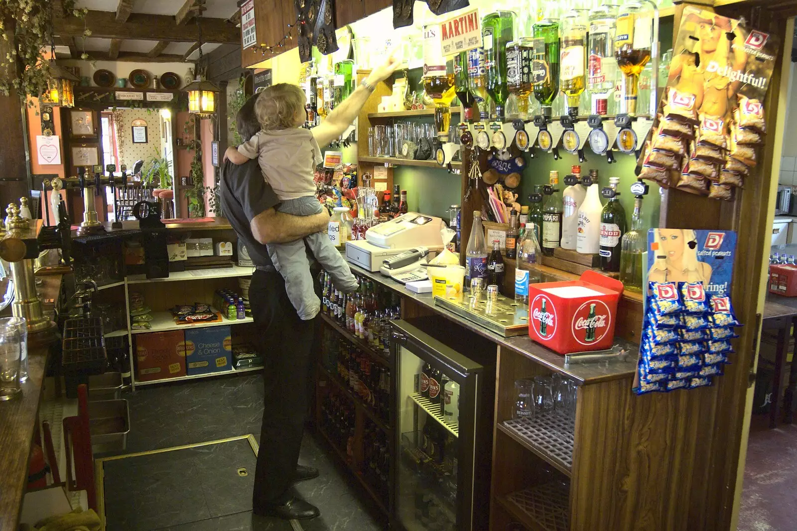 Alan lifts Fred up to explore behind the bar, from Fred Visits The Swan, Brome, Suffolk - 5th February 2011