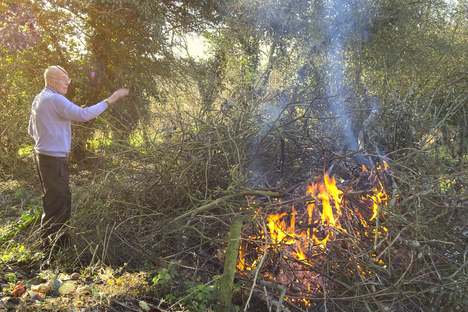 Grandad lobs sticks onto the fire from A Trip To The Coast, Walberswick, Suffolk - 20th March 2011