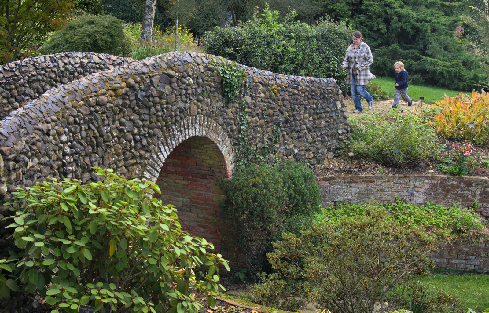 Isobel and Fred run over the flint bridge from Alan Bloom's Gardens, Bressingham, Norfolk - 6th October 2012