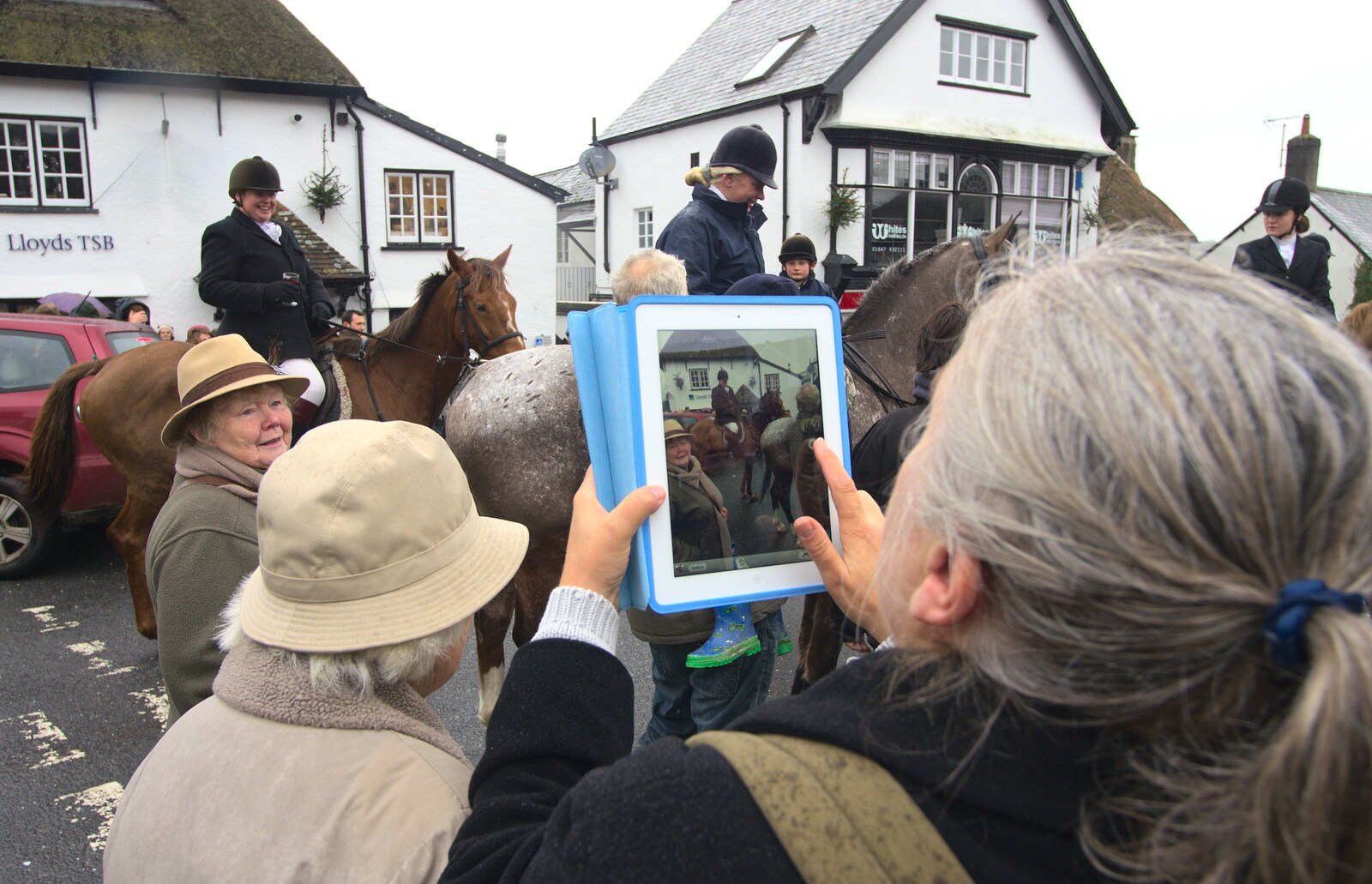A woman looks absurd using a pooPad to take a pic from The Boxing Day Hunt, Chagford, Devon - 26th December 2012