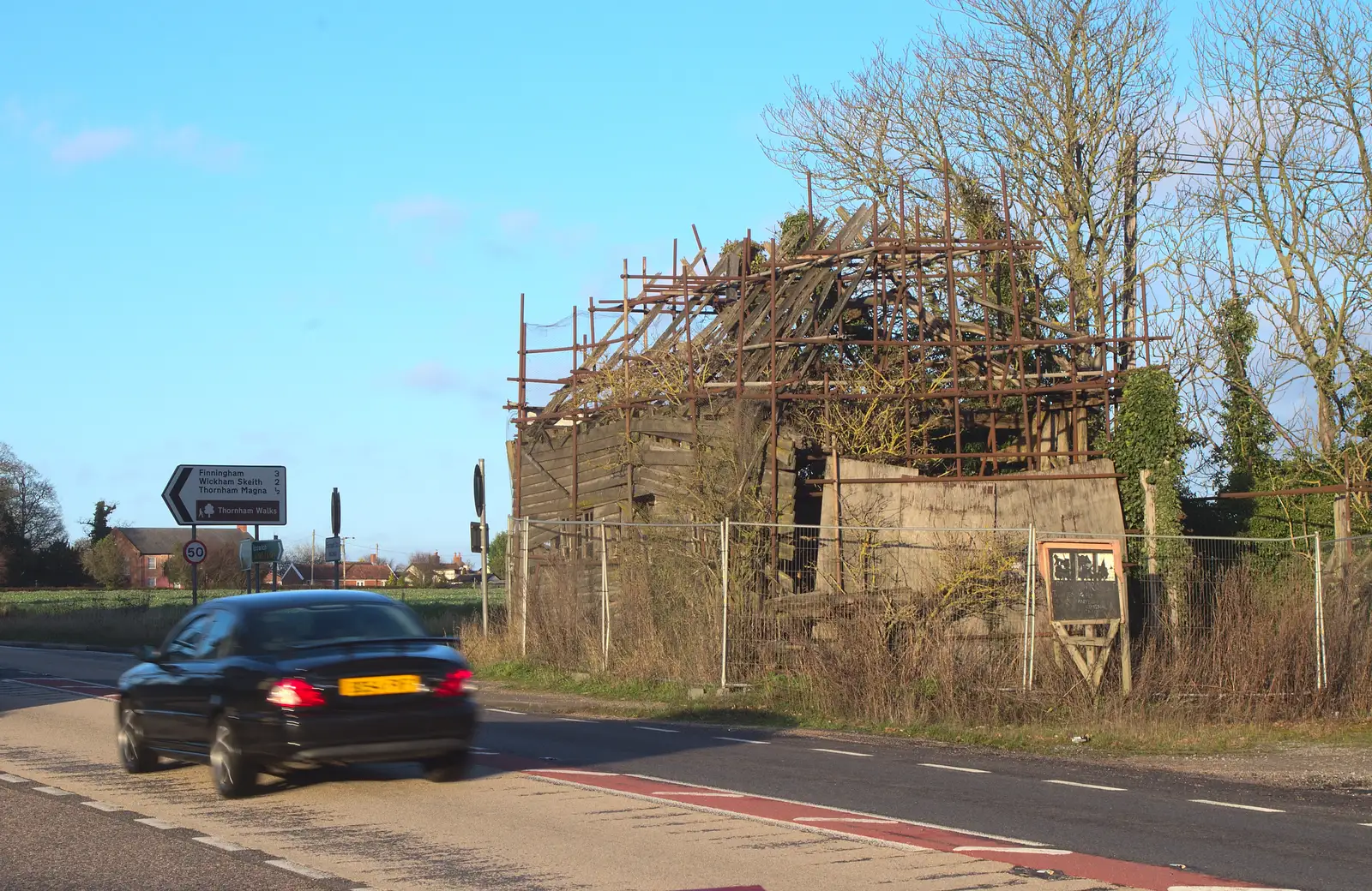 A car drives past the wrecked building, from New Year's Day and Lunch at the White Horse, Ipswich, Finningham and Brome - 1st January 2013