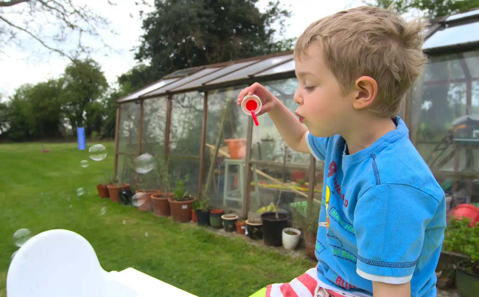 Fred blows bubbles near the greenhouse, from Bank Holiday Flowers, Brome, Suffolk - 6th May 2013