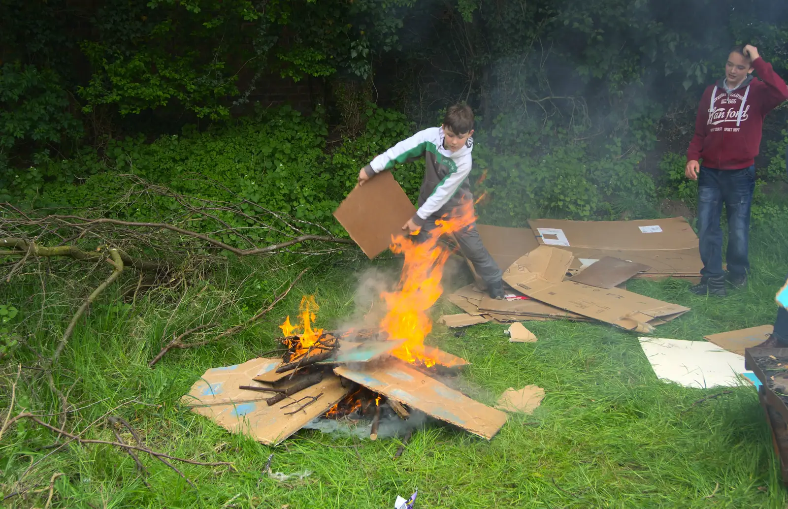 A boy fans the bonfire, from Demolishing The 1st Eye Scout Hut, Wellington Road, Eye, Suffolk - 11th May 2013