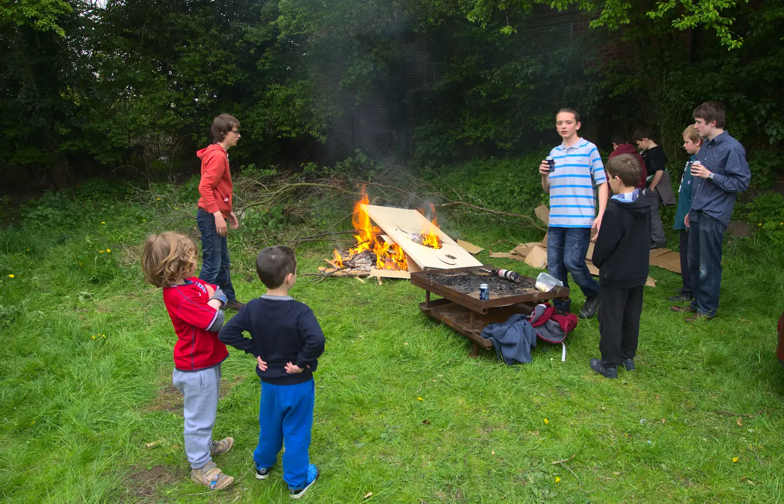 The door is hurled on the bonfire, from Demolishing The 1st Eye Scout Hut, Wellington Road, Eye, Suffolk - 11th May 2013