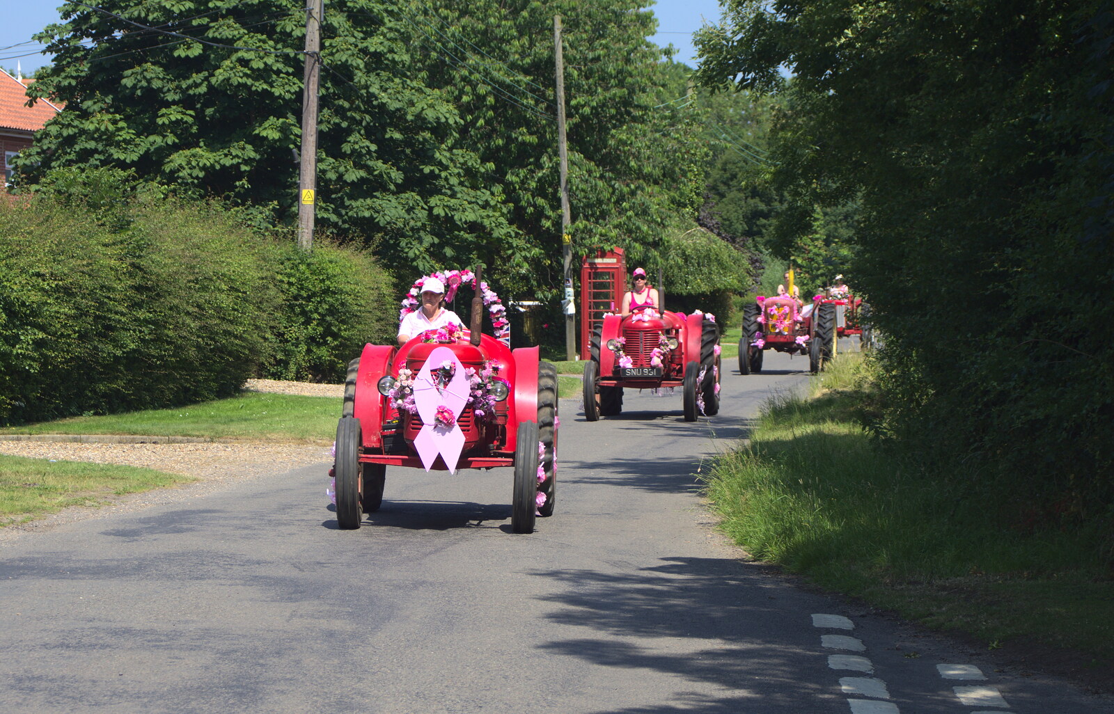 The first pink tractors rumble down the lane from The "Pink Ladies" Tractor Run and Barbeque, Thorpe Abbots, Norfolk - 7th July 2013