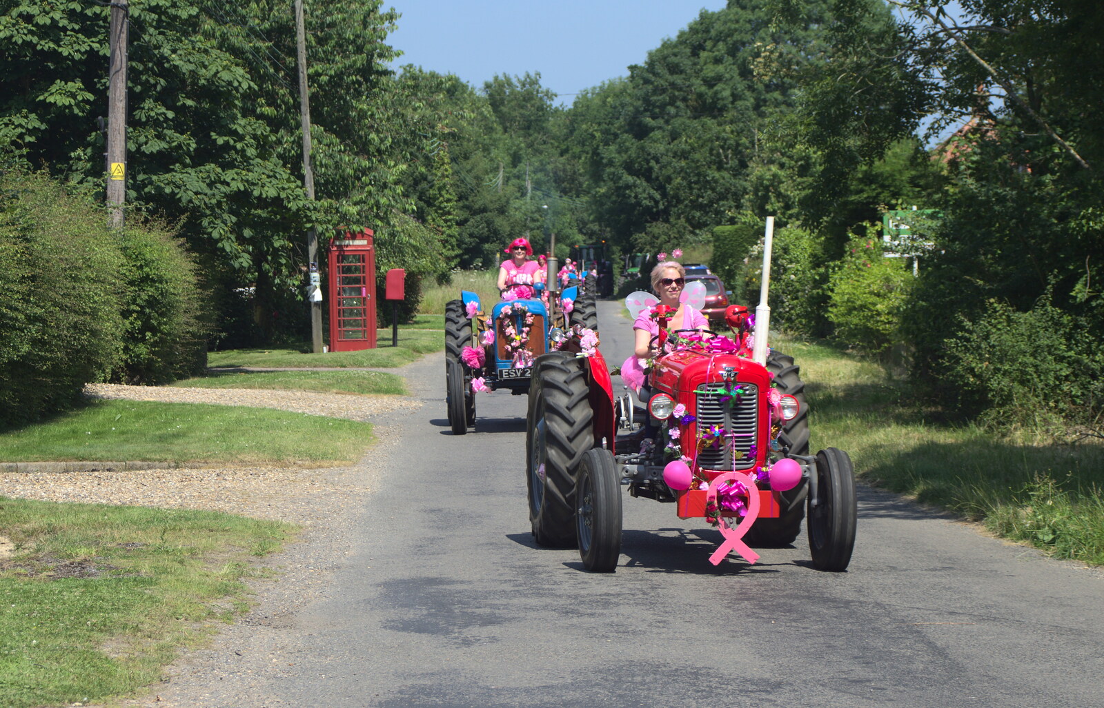 More tractors pass the phone box from The "Pink Ladies" Tractor Run and Barbeque, Thorpe Abbots, Norfolk - 7th July 2013