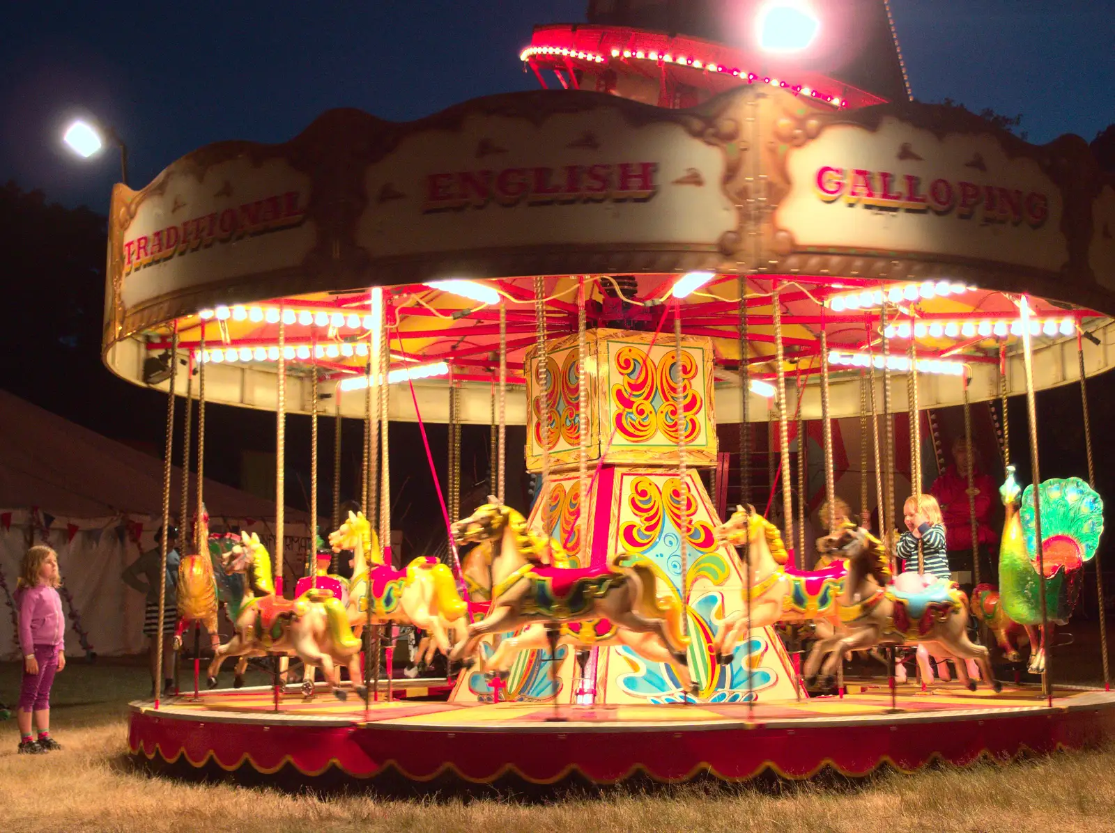 A girl watches the merry-go-round, from The 8th Latitude Festival, Henham Park, Southwold, Suffolk - 18th July 2013