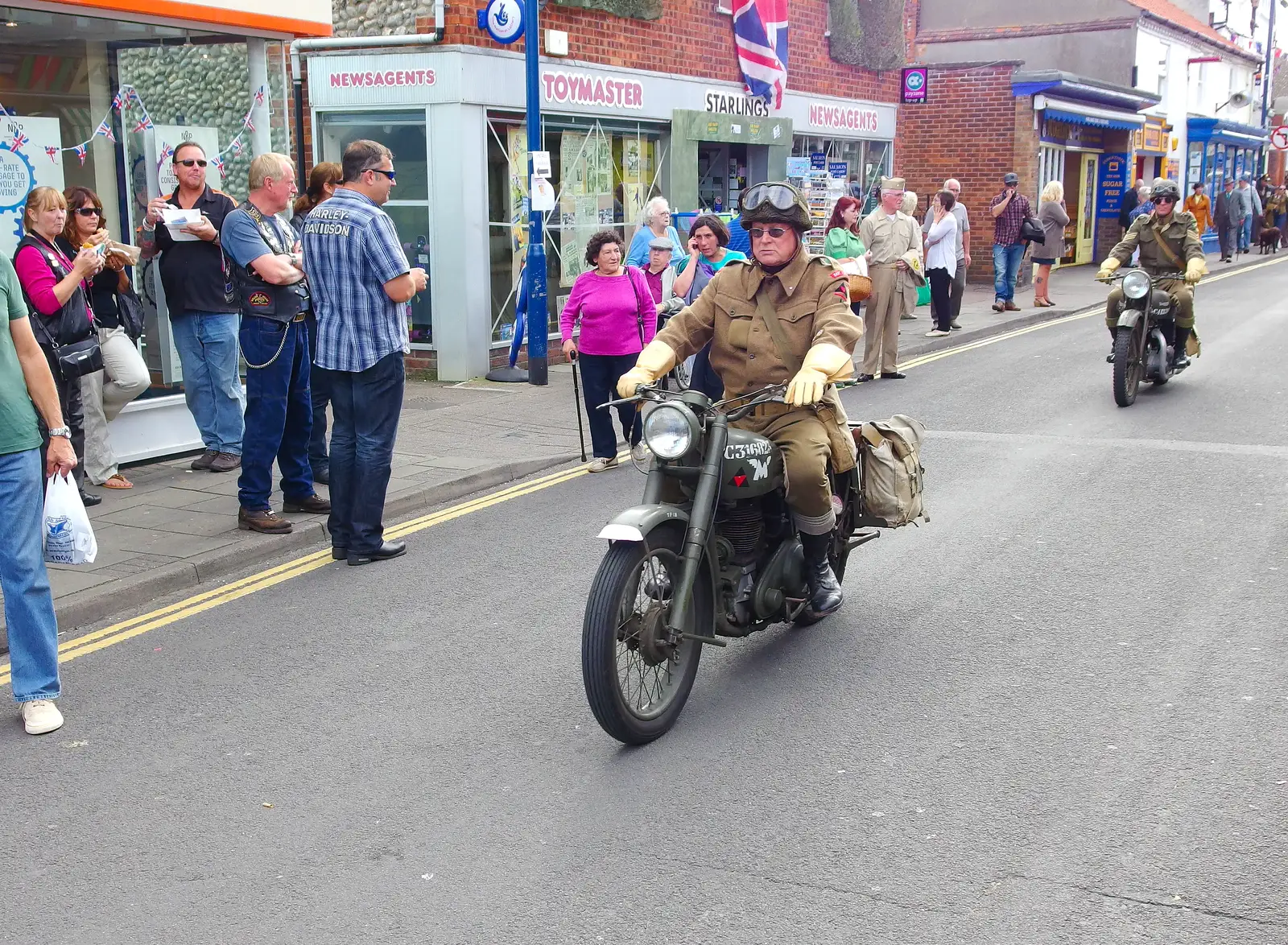 Wartime motorbikes cruise through town, from Paul Bear's Adventures at a 1940s Steam Weekend, Holt, Norfolk - 22nd September 2013