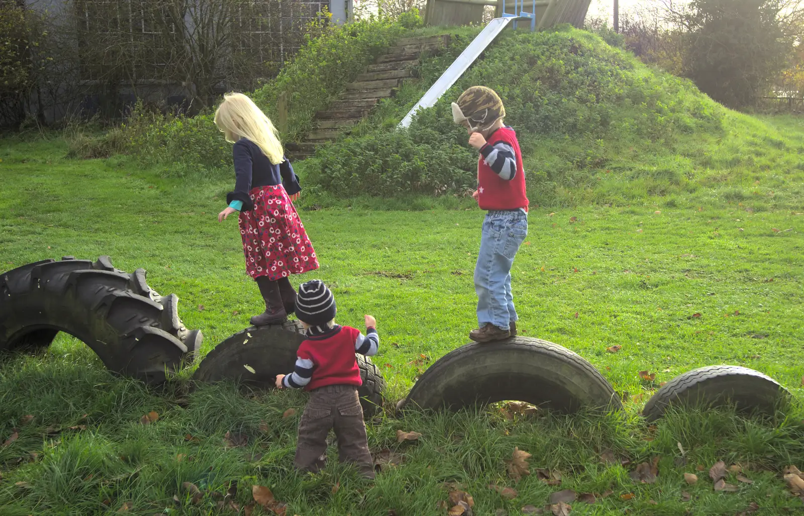 Milly, Harry and Fred mess around on the tyres, from More Building and Palgrave Playground, Suffolk - 24th November 2013