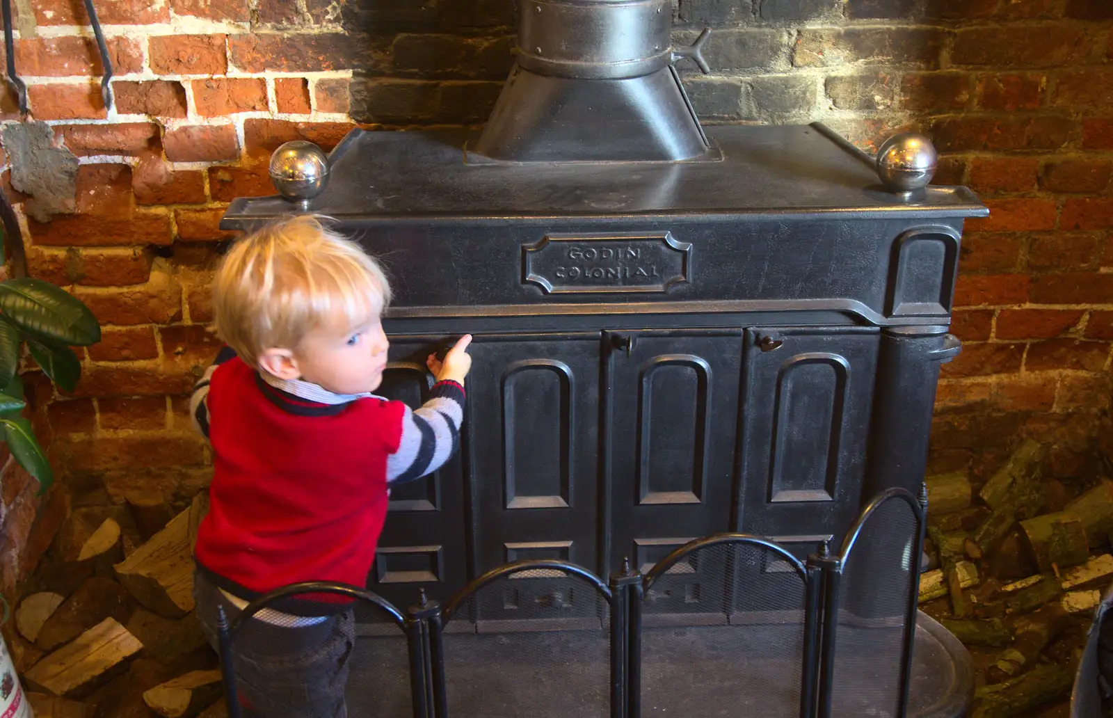 Harry pokes the wood burner, from Christmas Day and all that, Brome, Suffolk - 25th December 2013