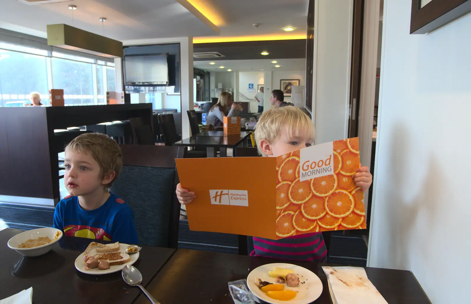 Harry checks out the breakfast menu at the Hotel, from A Day Out at Duxford, Cambridgeshire - 9th March 2014