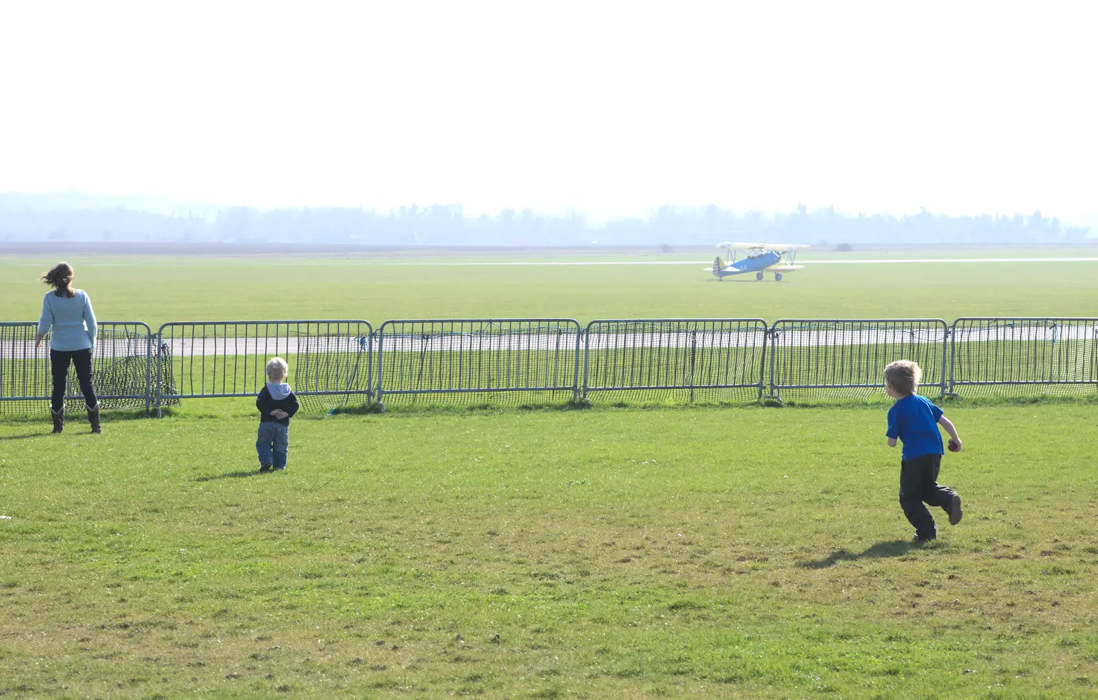 The Stearman lands as Fred runs around, from A Day Out at Duxford, Cambridgeshire - 9th March 2014